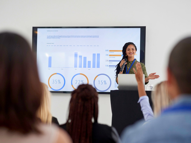 A young woman of color delivering a presentation at a conference